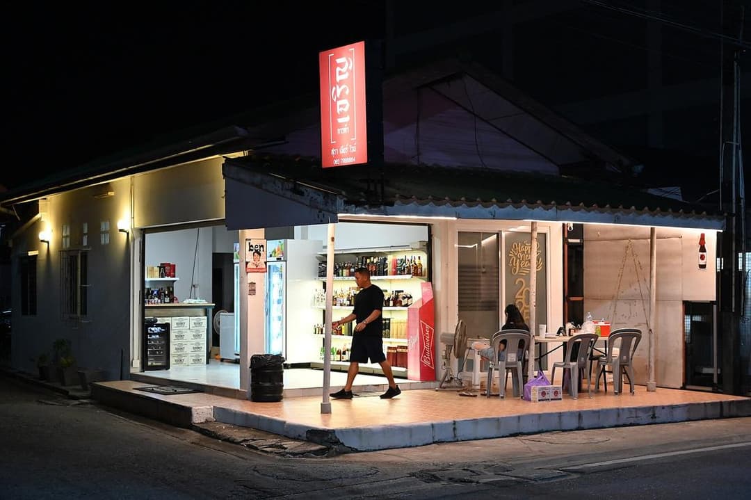 A small brightly lit corner shop at night