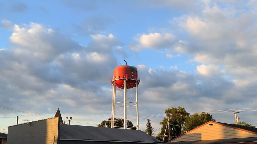 A small-town water tower against a cloudy sky