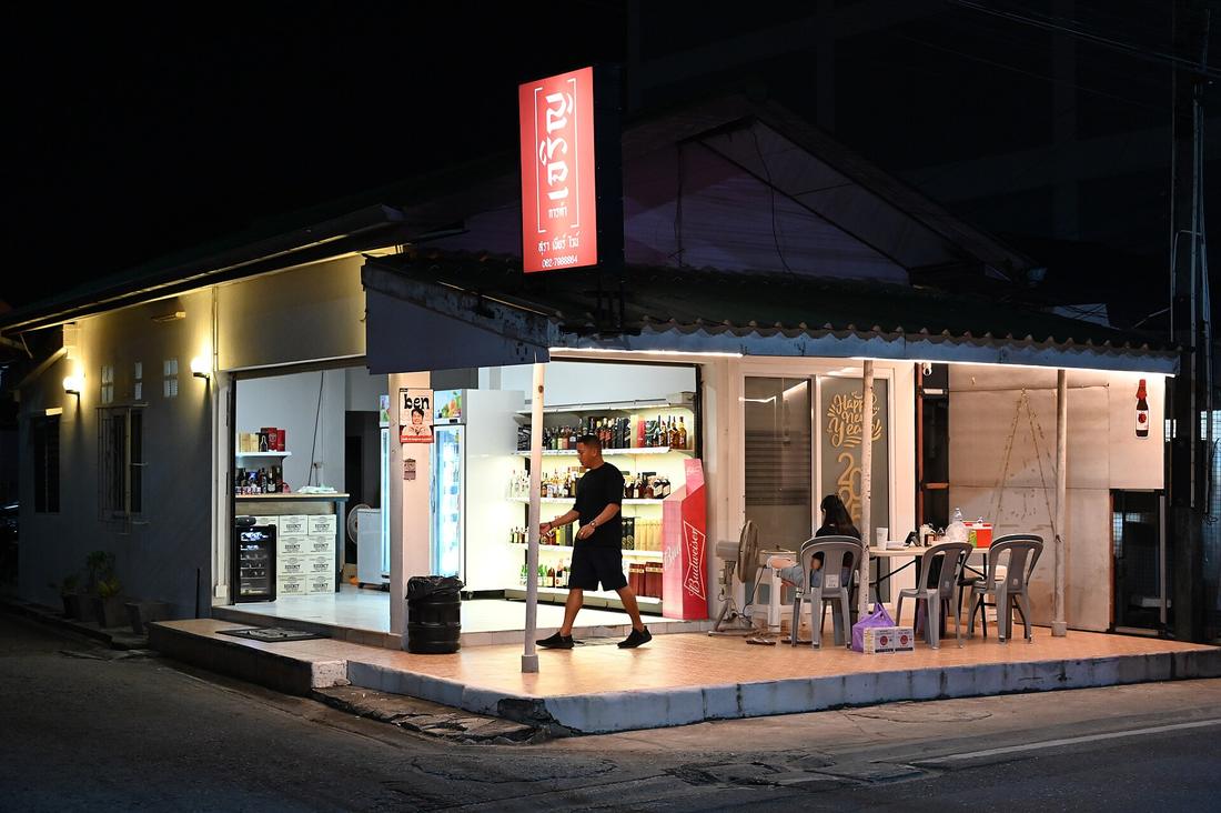 A small brightly lit corner shop at night