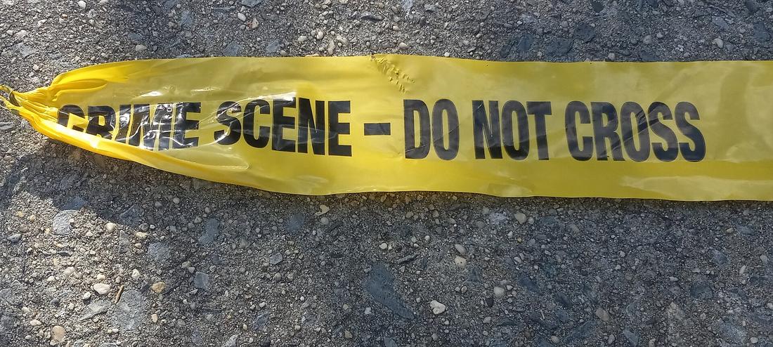 Police crime-scene tape stretched across a New York sidewalk
