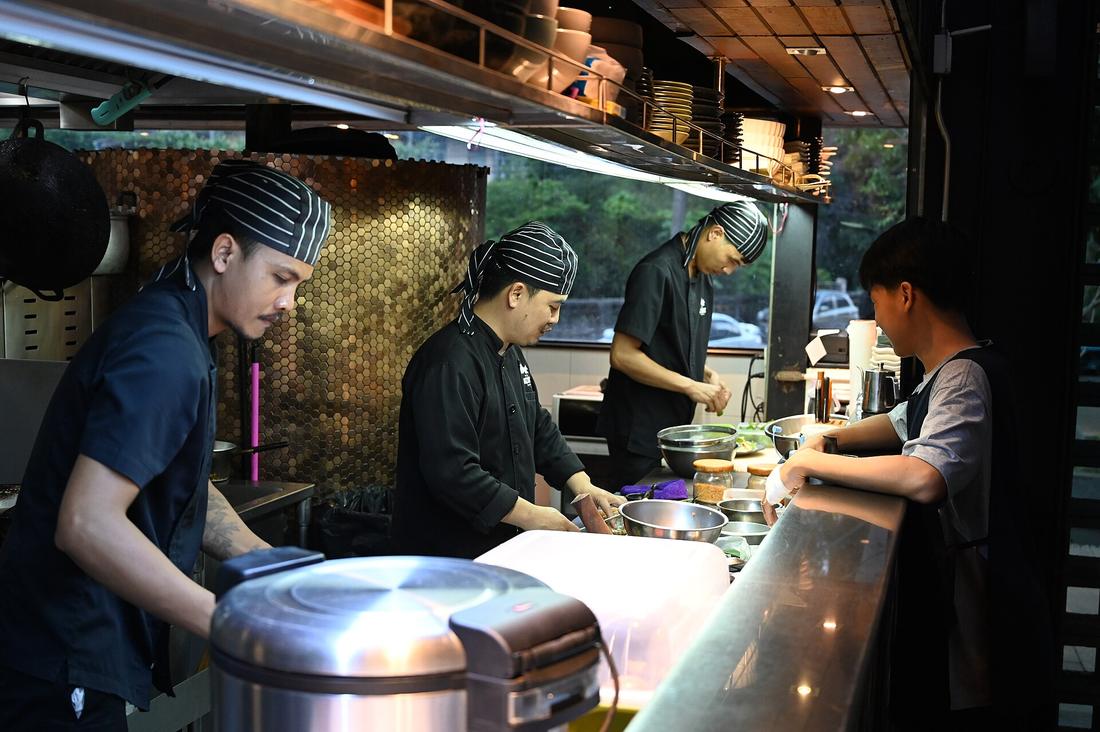 Kitchen staff preparing meals behind a restaurant counter