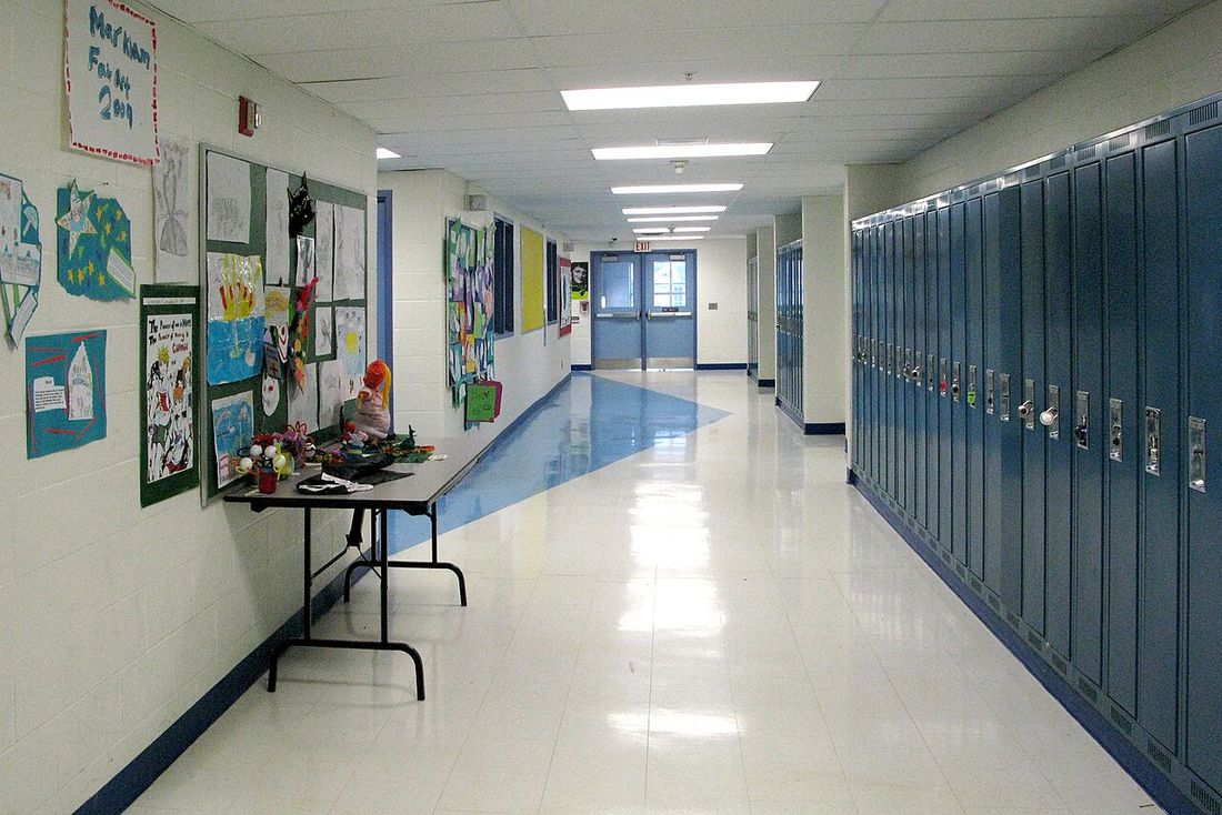 An empty school hallway hung with pupils' artwork