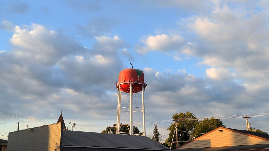 A small-town water tower against a cloudy sky